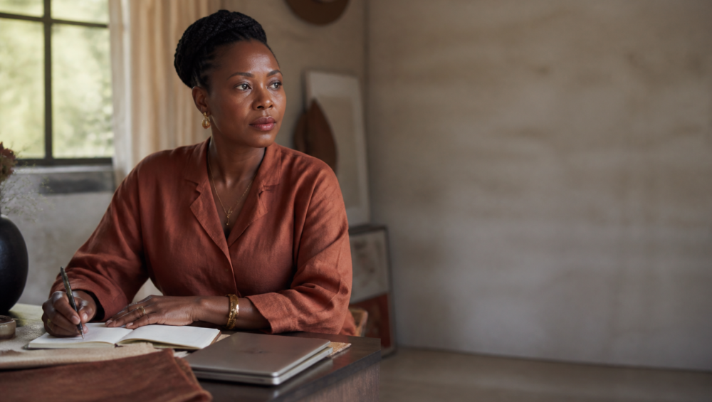 Maman entrepreneure Afrique travaillant dans un studio élégant à Kinshasa, illustrant la conciliation business et famille.