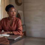 Maman entrepreneure Afrique travaillant dans un studio élégant à Kinshasa, illustrant la conciliation business et famille.