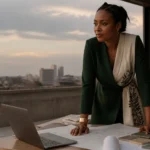 Entrepreneure congolaise travaillant sur son pitch deck dans un studio à Kinshasa, lumière de fin de journée.