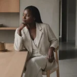 Fondatrice congolaise assise dans un intérieur minimaliste à Kinshasa, lumière naturelle douce