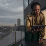 Femme fondatrice tech Afrique analysant des données IA sur une terrasse à Nairobi au crépuscule.